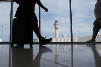 People walk at the Hartsfield-Jackson Atlanta International Airport terminal in Atlanta, Georgia in May 2025.