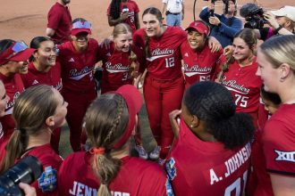 Texas Tech celebrates defeating defending champion Oklahoma to advance to the finals against Texas in the NCAA Softball WCWS.