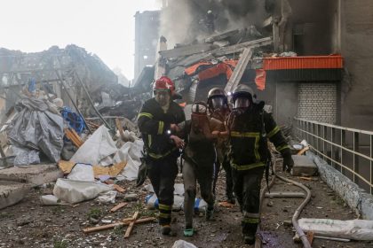 Rescuers assist an injured resident after she was released from debris of a building hit by a Russian drone strike in Kharkiv, Ukraine, on June 7, 2025.