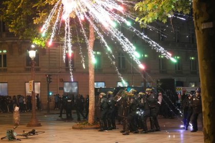 Fireworks explode over riot police officers on the Champs-Elysees in Paris.