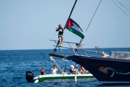 Climate activist Greta Thunberg stands next to a Palestinian flag after boarding the Madleen and before setting sail for Gaza with the Freedom Flotilla Coalition, leaving the Sicilian port of Catania on June 1.
