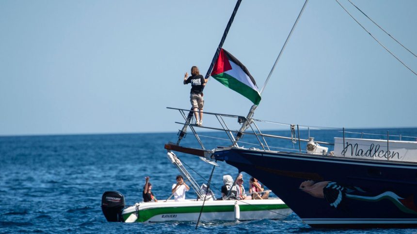 Climate activist Greta Thunberg stands next to a Palestinian flag after boarding the Madleen and before setting sail for Gaza with the Freedom Flotilla Coalition, leaving the Sicilian port of Catania on June 1.