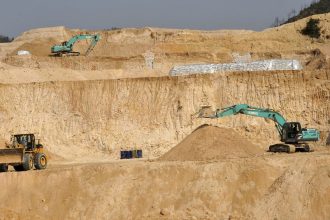Workers use machinery to dig at a rare earth mine in Ganxian county in central China's Jiangxi province in 2010.