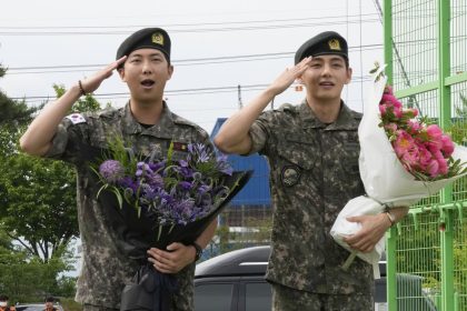 K-pop band BTS members RM, left, and V salute after being discharged from a mandatory military service in Chuncheon, South Korea, on Tuesday.