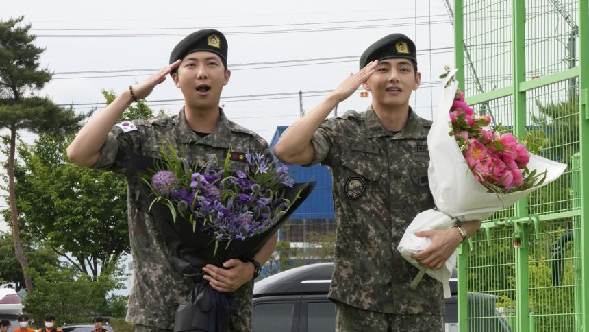 K-pop band BTS members RM, left, and V salute after being discharged from a mandatory military service in Chuncheon, South Korea, on Tuesday.