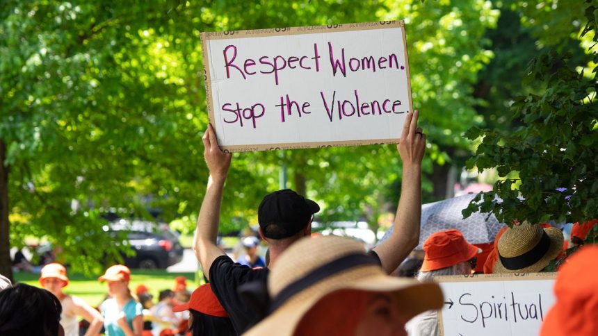 An attendee holds a sign during a march demanding an end to domestic violence and femicide in Melbourne, Australia, on November 22, 2024.