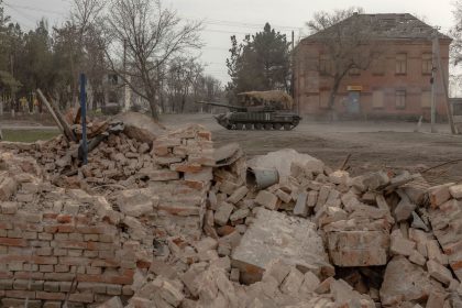 A Ukrainian tank drives on a road past buildings damaged by shelling in a village in the Dnipropetrovsk region on March 16.