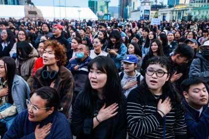 People sing during a protest calling for the resignation of Mongolia's Prime Minister Oyun-Erdene Luvsannamsrain at Sukhbaatar Square in Ulaanbaatar on May 21, 2025.