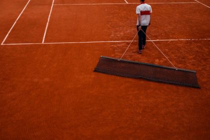 A staff sweeps a clay court during the French Open tennis tournament at the Roland-Garros Complex in Paris on May 24, 2025. (Photo by Dimitar DILKOFF / AFP) (Photo by DIMITAR DILKOFF/AFP via Getty Images)