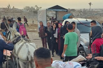 Displaced Palestinians watch as others push a cart carrying the bodies of those reportedly hit by Israeli fire near a food distribution center in Rafah, in the southern Gaza Strip on Sunday, June 1.