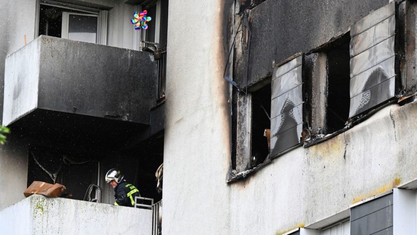 A firefighter secures an apartment building where a blaze broke out overnight in Reims on June 6.