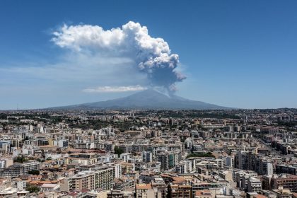 CATANIA, ITALY - JUNE 02: Mount Etna exhibits a Strombolian eruption, with a volcanic plume rising from the southeast crater, on June 02, 2025 in Catania, Italy. An orange aviation warning has been issued. The images show aerial views of the volcano with the city of Catania in the background. (Photo by Fabrizio Villa/Getty Images)