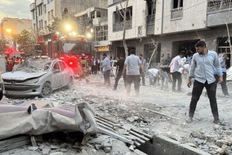 People and first-responders gather outside a building that was hit by an Israeli strike in Tehran on June 13, 2025. Israel hit about 100 targets in Iran on June 13, including nuclear facilities and military command centres and killing senior figures including the armed forces chief and top nuclear scientists. (Photo by MEGHDAD MADADI / TASNIM NEWS / AFP) (Photo by MEGHDAD MADADI/TASNIM NEWS/AFP via Getty Images)